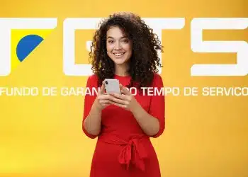 Jovem segurando smartphone sorrindo em frente ao logo do FGTS em fundo amarelo