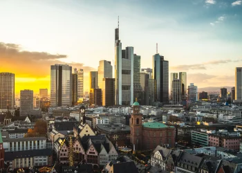 Vista panorâmica de Frankfurt, Alemanha, com seus arranha-céus contrastando com a arquitetura histórica.