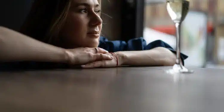 Pessoa pensativa olhando pela janela, representando a busca por um propósito de vida.