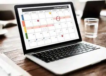 Notebook exibindo um calendário digital com datas destacadas e marcações de feriados, representando o planejamento de feriados estendidos em 2026.