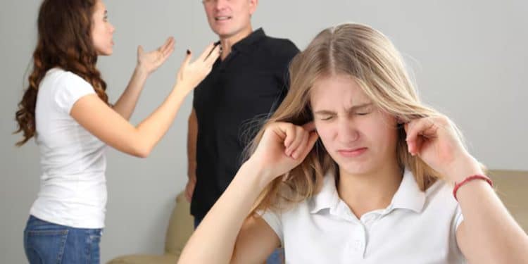 Jovem tampando os ouvidos enquanto presencia uma briga entre adultos, ilustrando o impacto da violência doméstica e trauma infantil