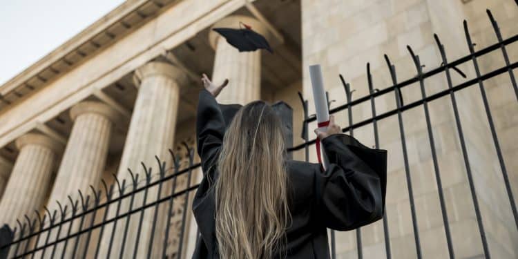 Estudante formada em Direito comemorando a graduação, representando o objetivo de ingressar nas melhores faculdades públicas pelo Enem.
