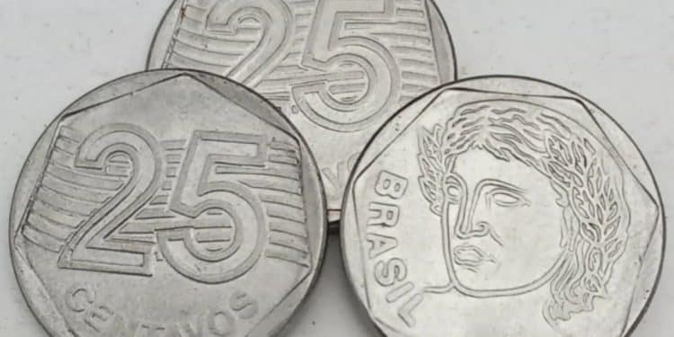 Três moedas de 25 centavos brasileiras, com uma delas virada para o anverso, mostrando a efígie da República e o ano de 1995.
