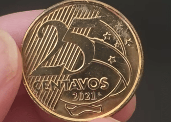 Close-up de uma moeda brasileira de 25 centavos do ano de 2021 sendo segurada, mostrando o valor e o ano em alto relevo, ideal para identificação de erros.