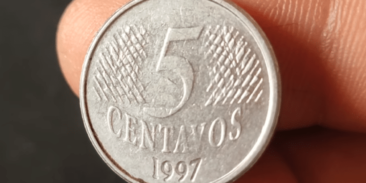 Close frontal de uma moeda prateada de 5 centavos do ano 1997, mostrando o algarismo central e a textura de linhas inclinadas ao fundo.