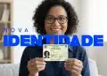 Mulher segurando Nova Carteira de Identidade Nacional e sorrindo em ambiente de sala