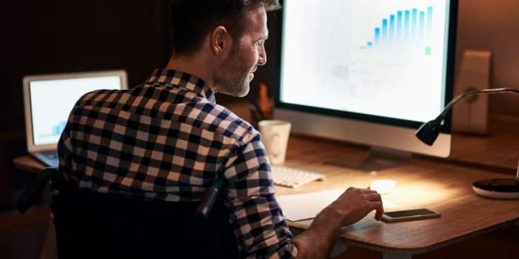 Especialista em Inteligência Artificial trabalhando remotamente, com gráfico de análise de dados na tela.