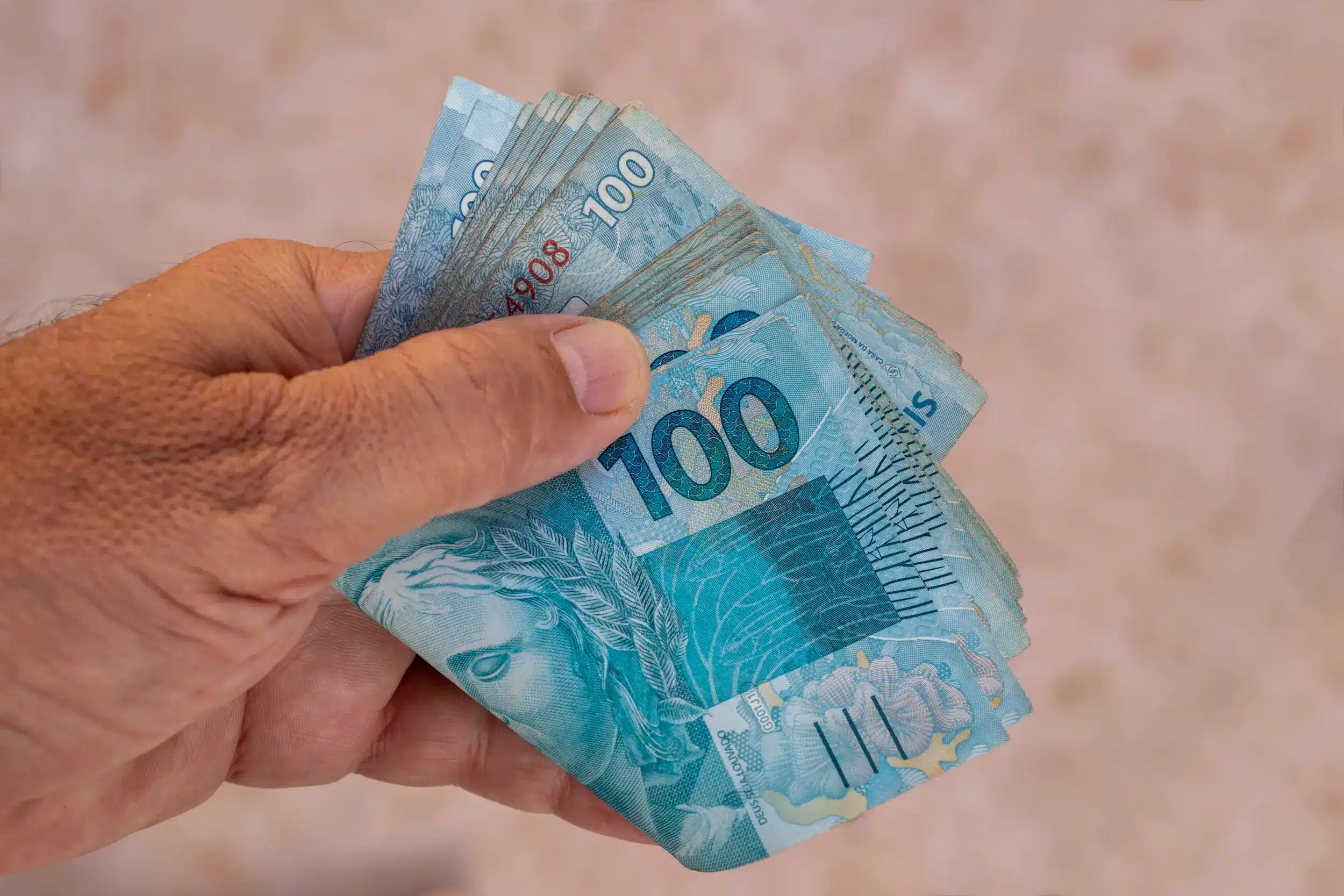 Notas de cem reais ilustrando matéria sobre ausência de pagamento do INSS na segunda-feira 16 de fevereiro.