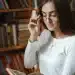Mulher lendo livro em biblioteca, refletindo sobre frases de inteligência.
