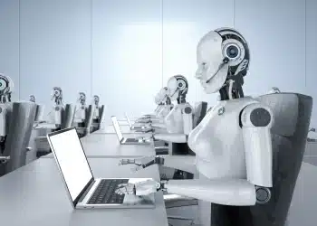 Robôs trabalhando em um escritório com laptops, representando a automação e a inteligência artificial substituindo várias profissões até 2030.