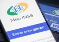 Imagem do simulador do INSS acessado pelo celular com cartão magnético da Previdência Social.