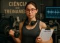 Mulher com óculos vermelhos segura halter e prancheta em laboratório de ciências do treinamento
