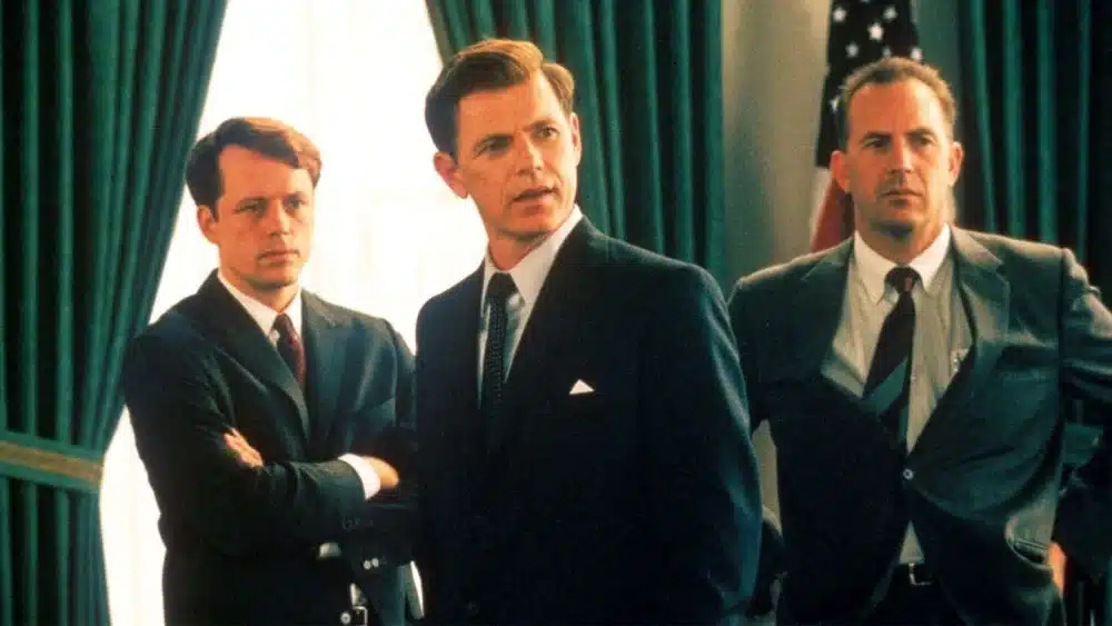 Cena tensa do filme 13 Dias que Abalaram o Mundo (2000), com três homens discutindo a crise dos mísseis cubanos.