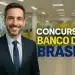 Homem de terno sorridente em seu local de trabalho.