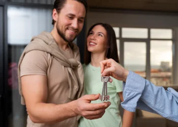 Casal feliz recebendo as chaves do imóvel após contemplação no consórcio.
