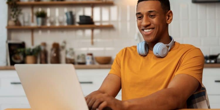 Jovem utilizando notebook para estudar tecnologia em curso online de qualificação profissional.