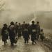Imagem retratando a migração forçada durante a Primeira Guerra Mundial, com um grupo de pessoas caminhando pela estrada, simbolizando os deslocamentos causados pelo conflito.
