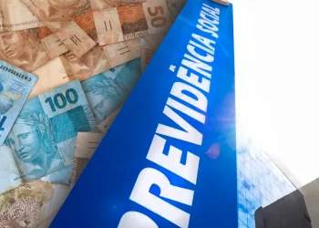 Fachada da Previdência Social com notas de real representando pagamento do INSS que pode ter valor maior em março de 2026