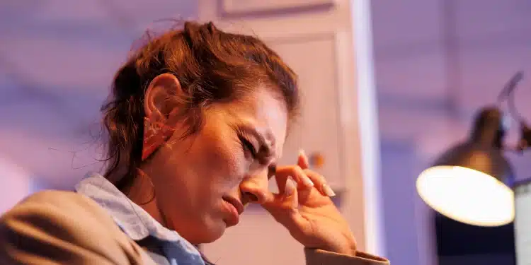 Mulher com expressão de preocupação levando a mão à testa, representando o impacto dos pensamentos obsessivos do TOC na vida cotidiana.