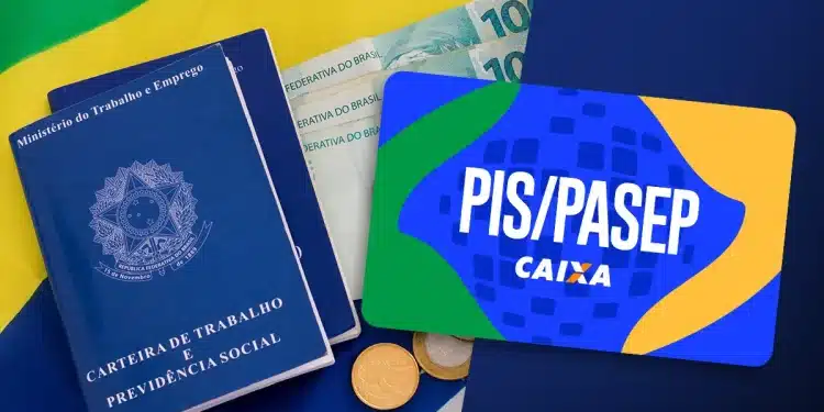 Carteira de trabalho brasileira ao lado de dinheiro em reais e cartão do PIS/Pasep representando o pagamento do novo lote do abono salarial.