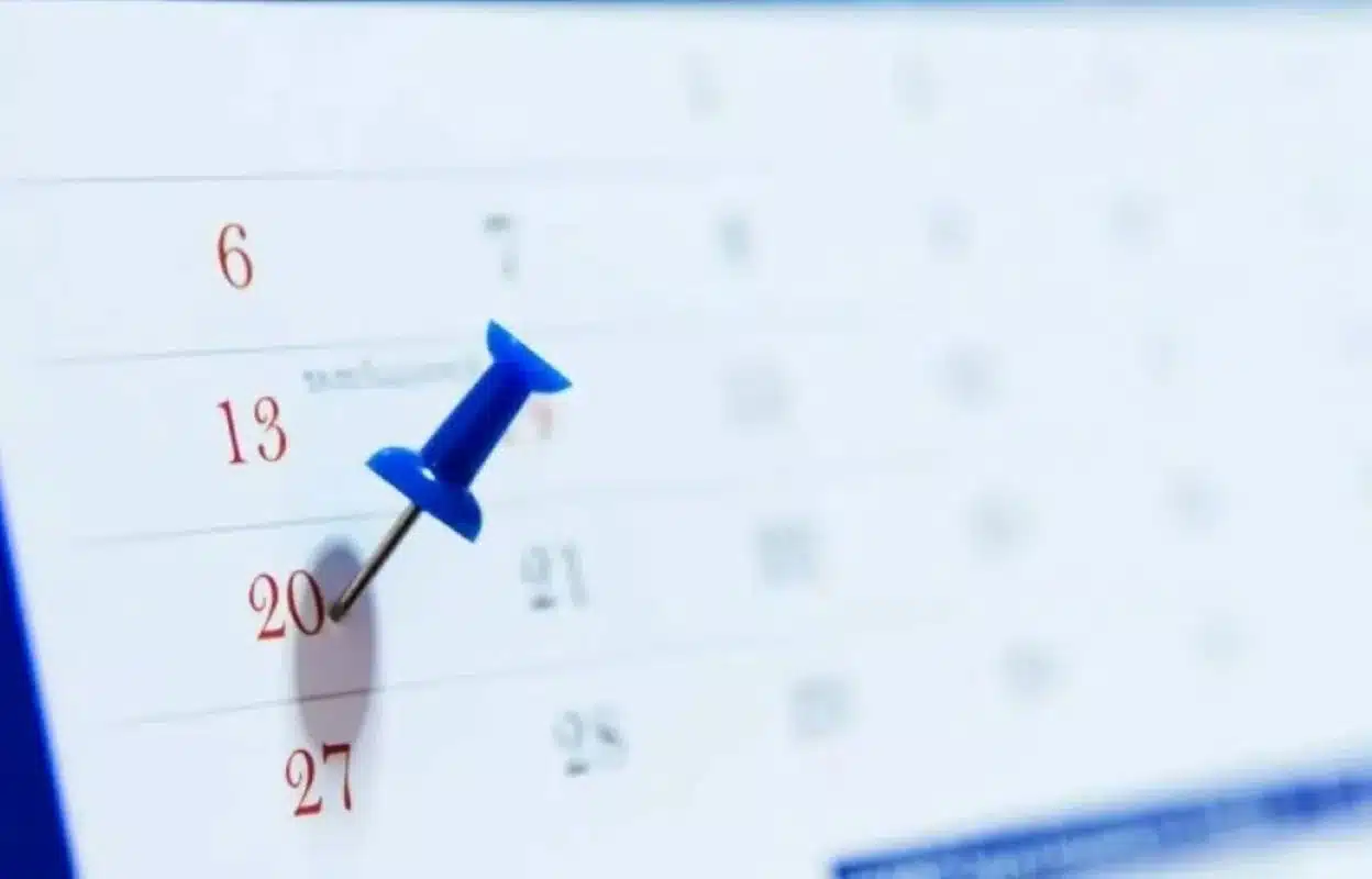 Alfinete azul fixado em uma data de calendário indicando dia importante ou possível feriado no mês de março.