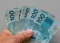 Notas de 100 reais representam a possível antecipação do décimo terceiro salário para beneficiários do INSS.