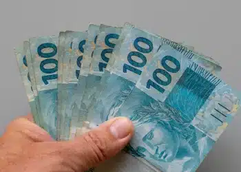 Notas de 100 reais representam a possível antecipação do décimo terceiro salário para beneficiários do INSS.