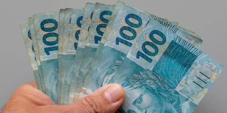 Notas de 100 reais representam a possível antecipação do décimo terceiro salário para beneficiários do INSS.