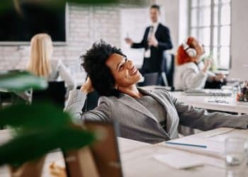 Profissional satisfeita em ambiente de escritório representa a importância do propósito e da realização no trabalho.