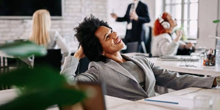 Profissional satisfeita em ambiente de escritório representa a importância do propósito e da realização no trabalho.