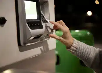 Pessoa utilizando caixa eletrônico representando as operações bancárias durante o período de feriados da Semana Santa.