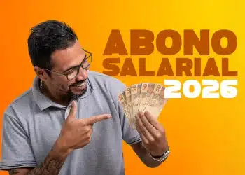 Homem sorridente usando óculos e camisa polo cinza, segurando várias notas de 50 reais e apontando para elas; ao fundo amarelo, o texto em destaque "ABONO SALARIAL 2026".