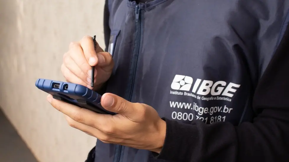Funcionário do IBGE utilizando tablet para coleta de dados em campo, representando movimentação do concurso 2026.