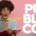 Mulher sorrindo com lápis e caderno, destacando anúncio de concurso público com vagas e salários altos.