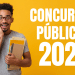 Jovem sorrindo segurando cadernos e apostilas diante de fundo amarelo com texto concursos públicos 2026.