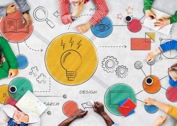 Equipe colaborando em mesa com ilustrações de lâmpada criativa, simbolizando inovação, educação e desenvolvimento de competências do futuro.