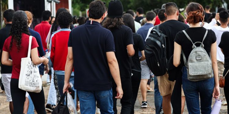 Grupo de jovens caminhando em direção a uma instituição de ensino — cursos tecnólogos estão entre as formações com maiores salários no Brasil em 2026