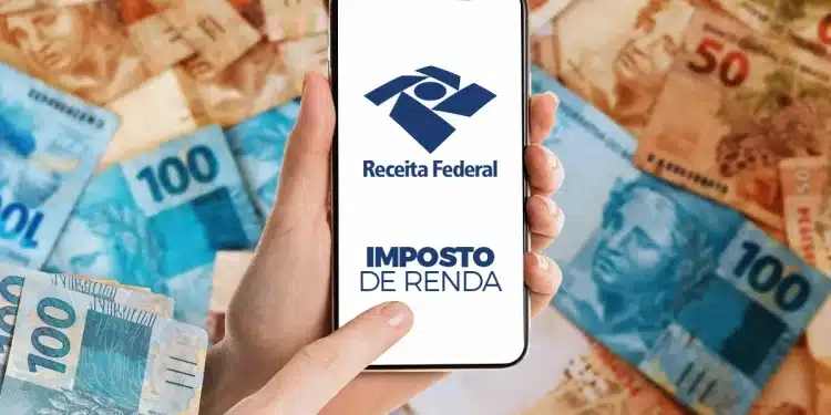 Mão segurando celular com logotipo da Receita Federal e Imposto de Renda sobre fundo de cédulas de reais
