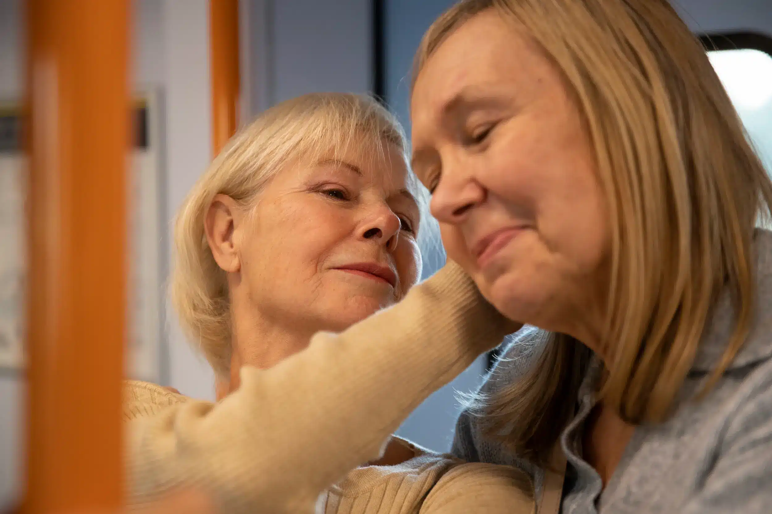 Mulher idosa com expressão de preocupação tocando o rosto, simbolizando frustração causada por falta de reciprocidade emocional em amizades.