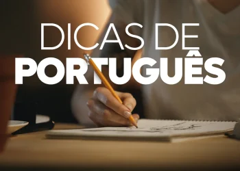 Close das mãos de uma pessoa escrevendo em um caderno com um lápis, sob uma iluminação suave, com o texto sobreposto em letras brancas garrafais dizendo "DICAS DE PORTUGUÊS".