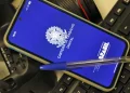 Celular com a tela inicial do aplicativo Carteira de Trabalho Digital do Governo Federal apoiado sobre teclado — veja como emitir o documento pelo app em 2026