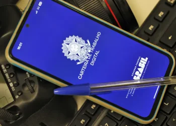 Celular com a tela inicial do aplicativo Carteira de Trabalho Digital do Governo Federal apoiado sobre teclado — veja como emitir o documento pelo app em 2026