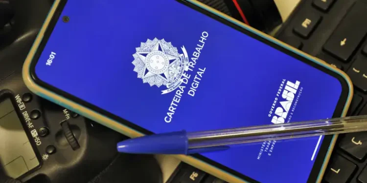 Celular com a tela inicial do aplicativo Carteira de Trabalho Digital do Governo Federal apoiado sobre teclado — veja como emitir o documento pelo app em 2026