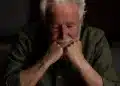 Homem idoso pensativo apoiando o rosto nas mãos, representando cansaço emocional após anos sendo o apoio de outras pessoas.