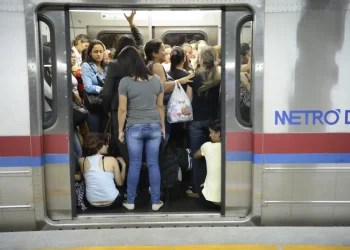 Passageiras aglomeradas na porta de vagão lotado do Metrô DF, ilustrando o ambiente de pressão e cansaço do transporte público urbano onde pequenos gestos de empatia, como ceder o lugar, podem promover bem-estar e saúde mental coletiva
