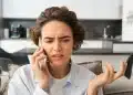 Mulher com expressão preocupada falando ao telefone após receber ligação suspeita de falso gerente de banco, golpe alertado pela Febraban.
