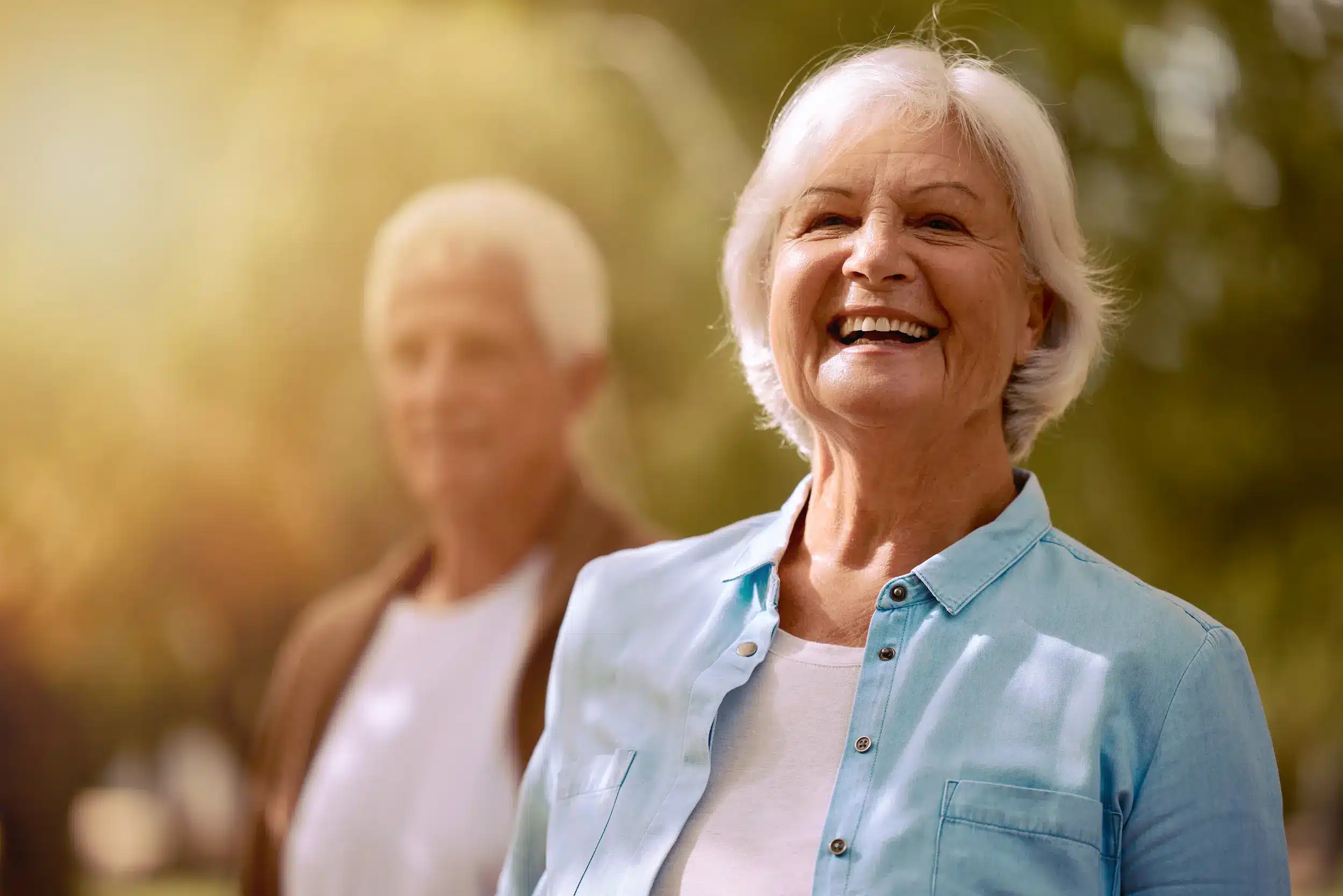Mulher idosa sorrindo ao ar livre simboliza bem-estar e mudanças positivas após os 60 anos.