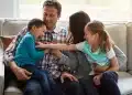 Família brincando juntos no sofá, representando os comportamentos comuns em adultos que foram o filho favorito durante a infância.
