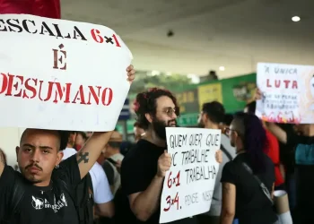 Protesto contra a escala 6x1 no Brasil com manifestantes segurando cartazes que criticam a jornada de trabalho considerada desumana.