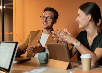 Frases que prejudicam a carreira: profissionais conversando em reunião de trabalho com comunicação assertiva